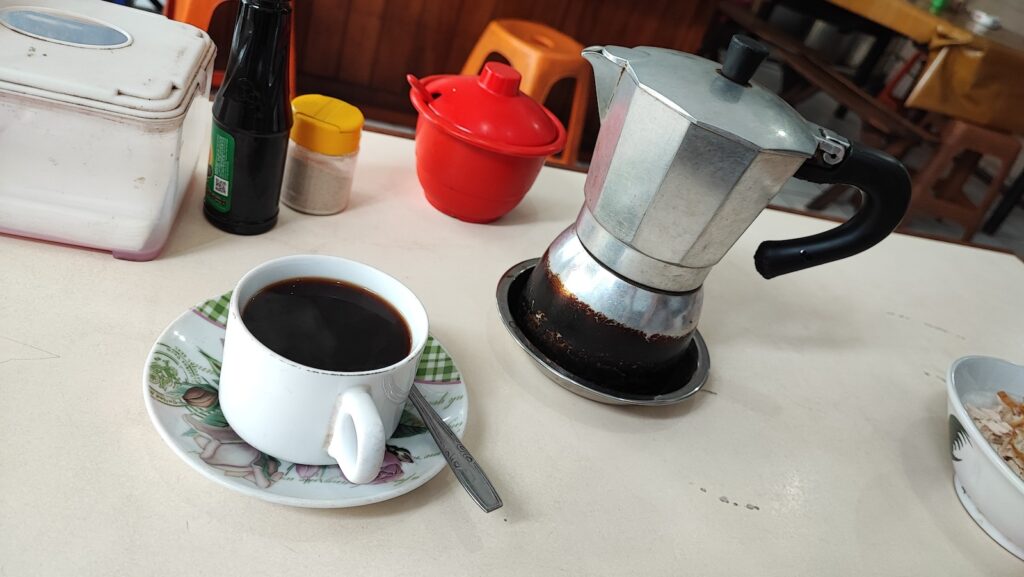 A cup of cofee and a huge mokapot