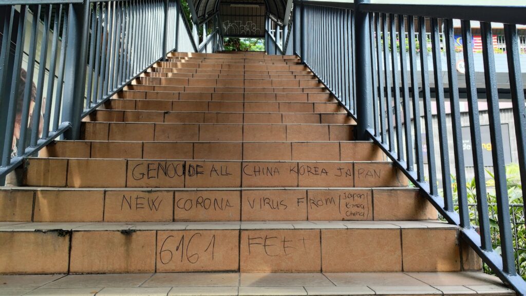 Staircases of pedestrian bridge with some writings on it.