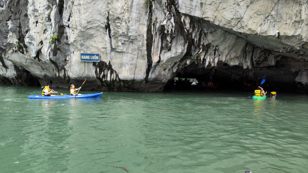 Picture of the rocks with some people kayaking. A "Hang Luon" sign is posted there.