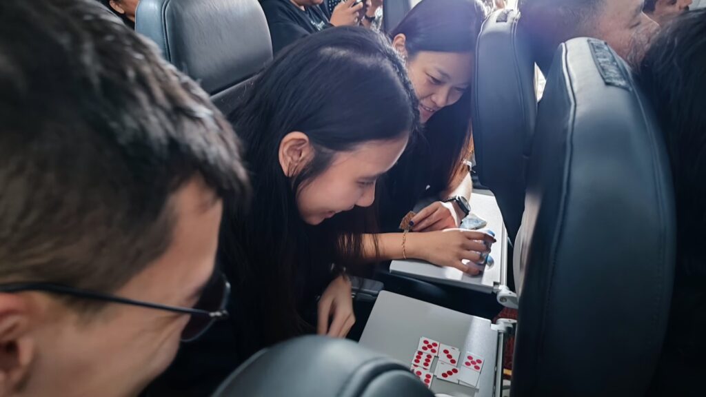 Three persons playing dominoes game in an airplane.